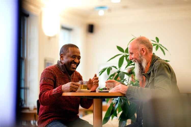 Men sitting at table laughing 