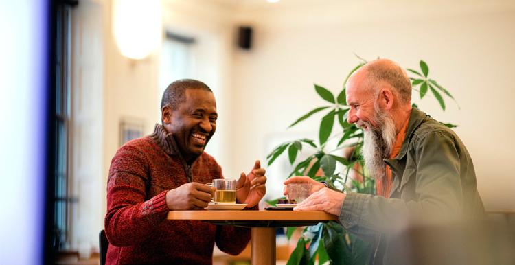 Men laughing sitting at table