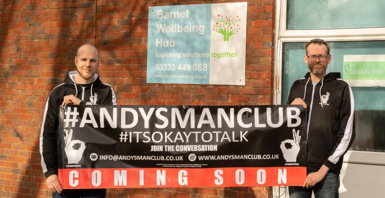 Two men with a banner in front of Barnet Wellbeing Hub