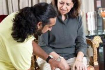 Physiotherapist with a adult Asian female patient sat in a chair