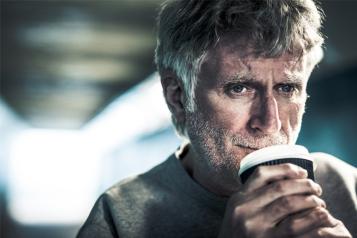 Thoughtful sad man holding a cup