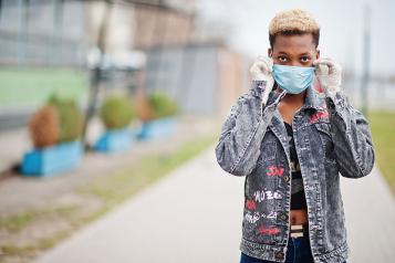 Black teenager wearing a mask