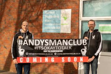 Two men with a banner in front of Barnet Wellbeing Hub