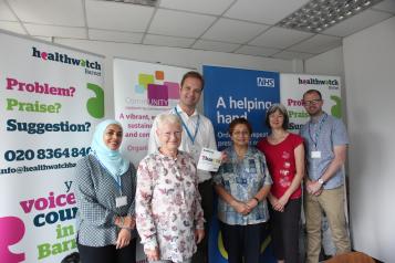 Three women and two men who are volunteers and staff standing