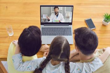 Mother and children talking to doctor via their laptop