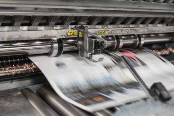 Photo of newspapers being printed