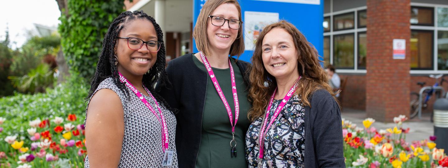 Three Healthwatch staff members standing outside a hospital