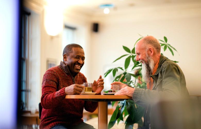 Men sitting at table laughing together